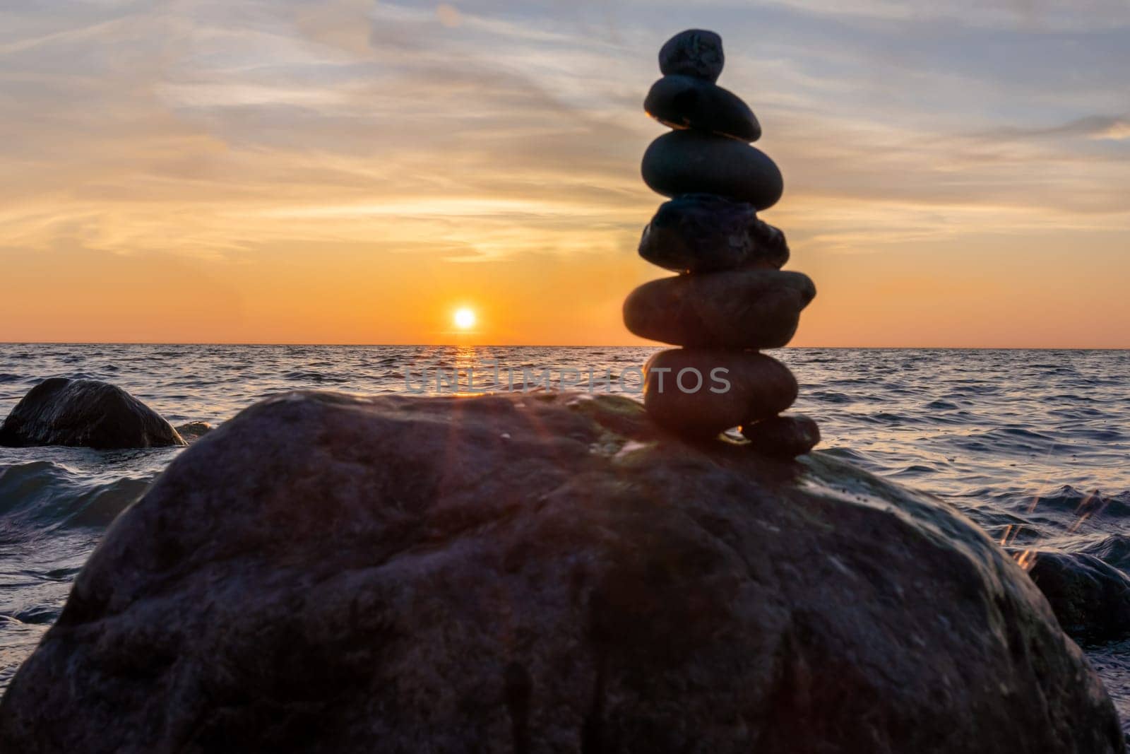 Stone pyramids and glass sphere on the dreamy Baltic Sea sand beach on Rügen for the spectacular sunset
