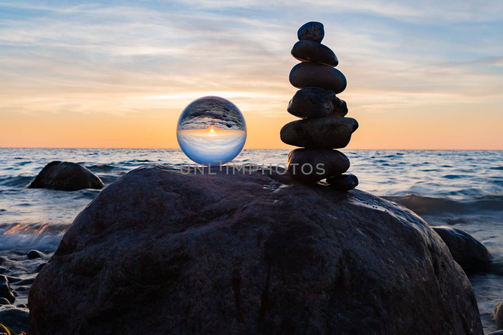 Stone pyramids and glass sphere on the dreamy Baltic Sea sand beach on Rügen for the spectacular sunset