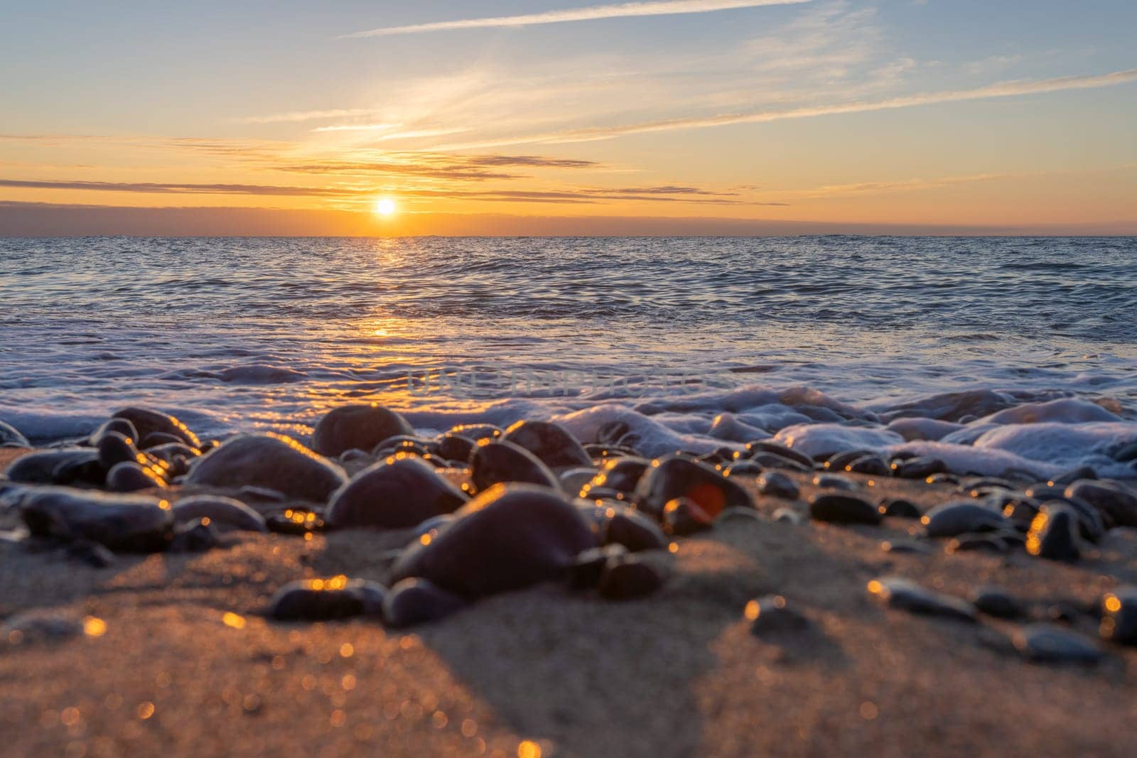 orange, sunset between rocks in the sea of the Baltic Sea near Dranske on the island of Rügen-	Beautiful sunset over the sea with waves and rocks in the foreground