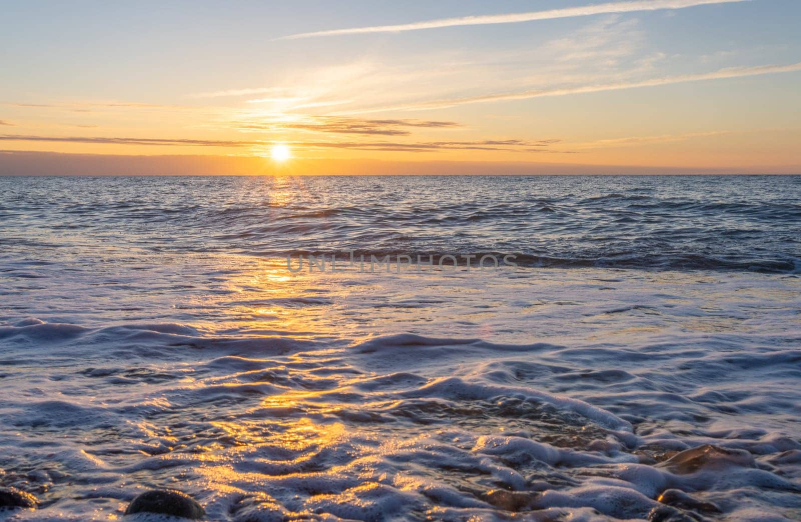 orange, sunset between rocks in the sea of the Baltic Sea near Dranske on the island of Rügen-	Beautiful sunset over the sea with waves and rocks in the foreground