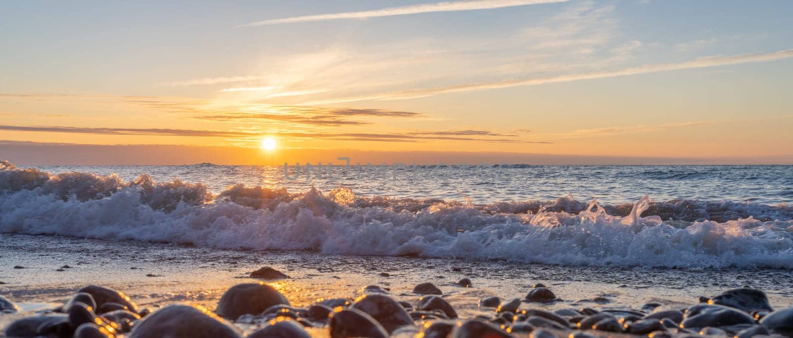 orange, sunset between rocks in the sea of the Baltic Sea near Dranske on the island of Rügen-	Beautiful sunset over the sea with waves and rocks in the foreground