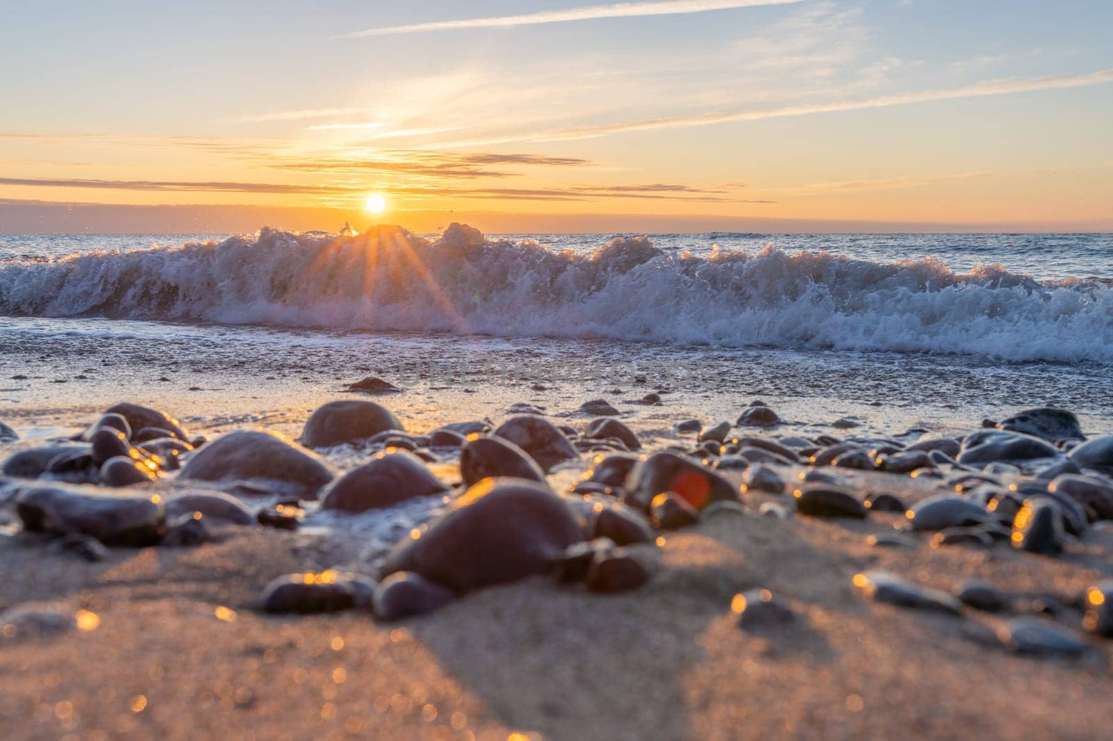 orange, sunset between rocks in the sea of the Baltic Sea near Dranske on the island of Rügen-	Beautiful sunset over the sea with waves and rocks in the foreground