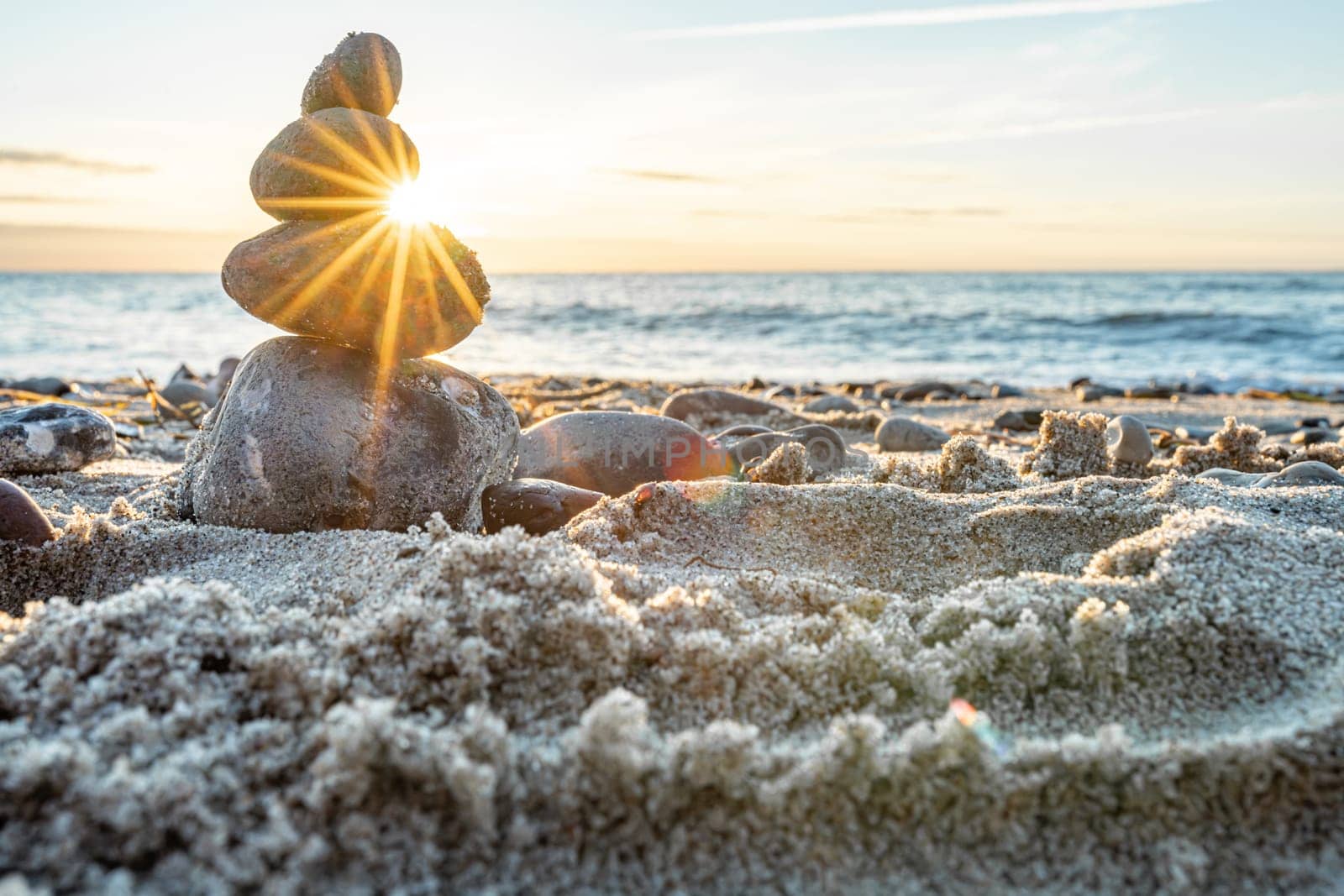 Stone pyramids and glass sphere on the dreamy Baltic Sea sand beach on Rügen for the spectacular sunset