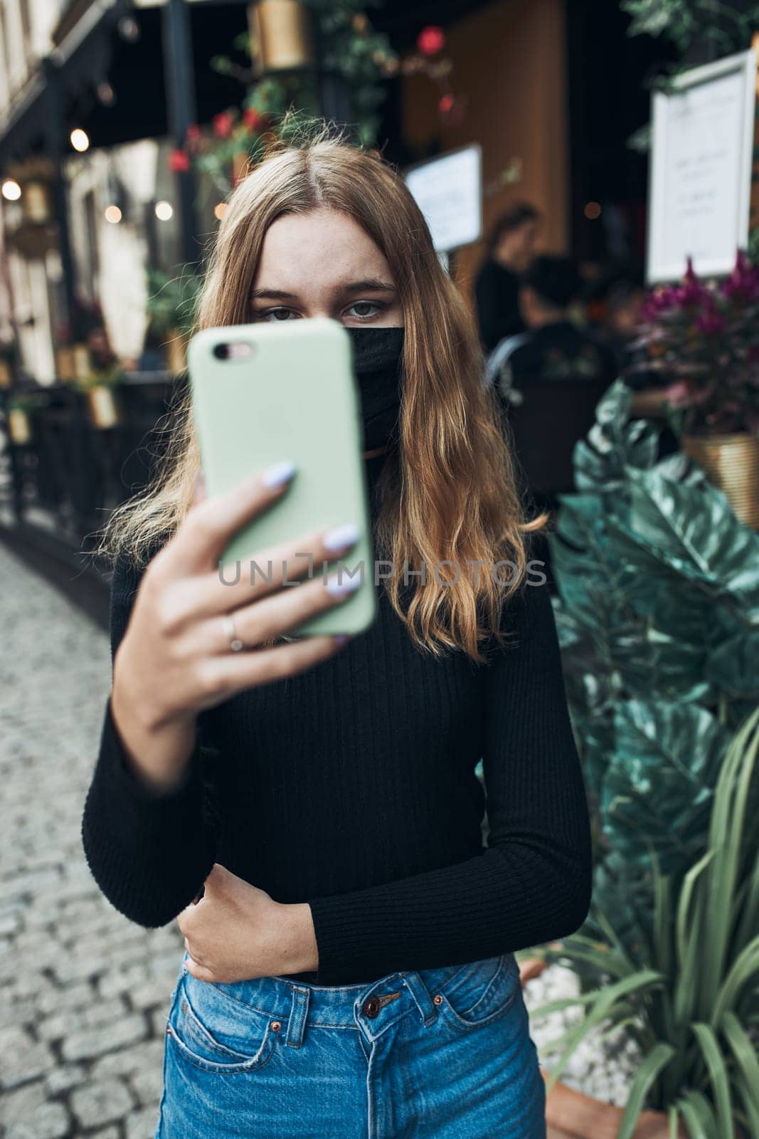 Young woman having video call talking while walking downtown wearing the face mask to avoid virus infection and to prevent the spread of disease in time of coronavirus