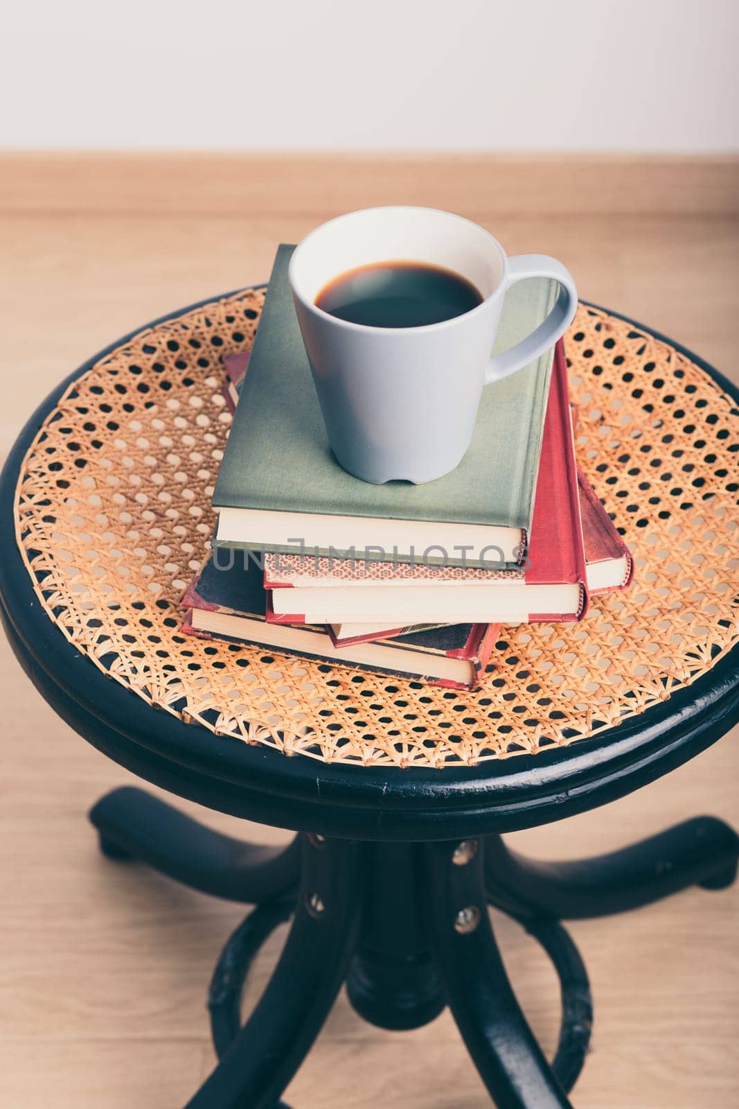 A few books with cup of coffee on chair