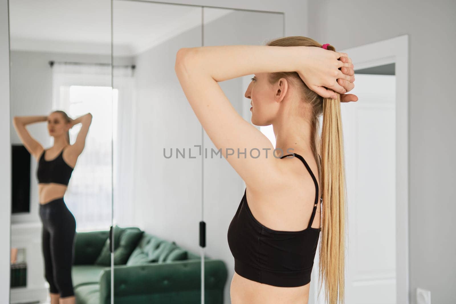 Young sporty woman put hands behind her head and does body twists