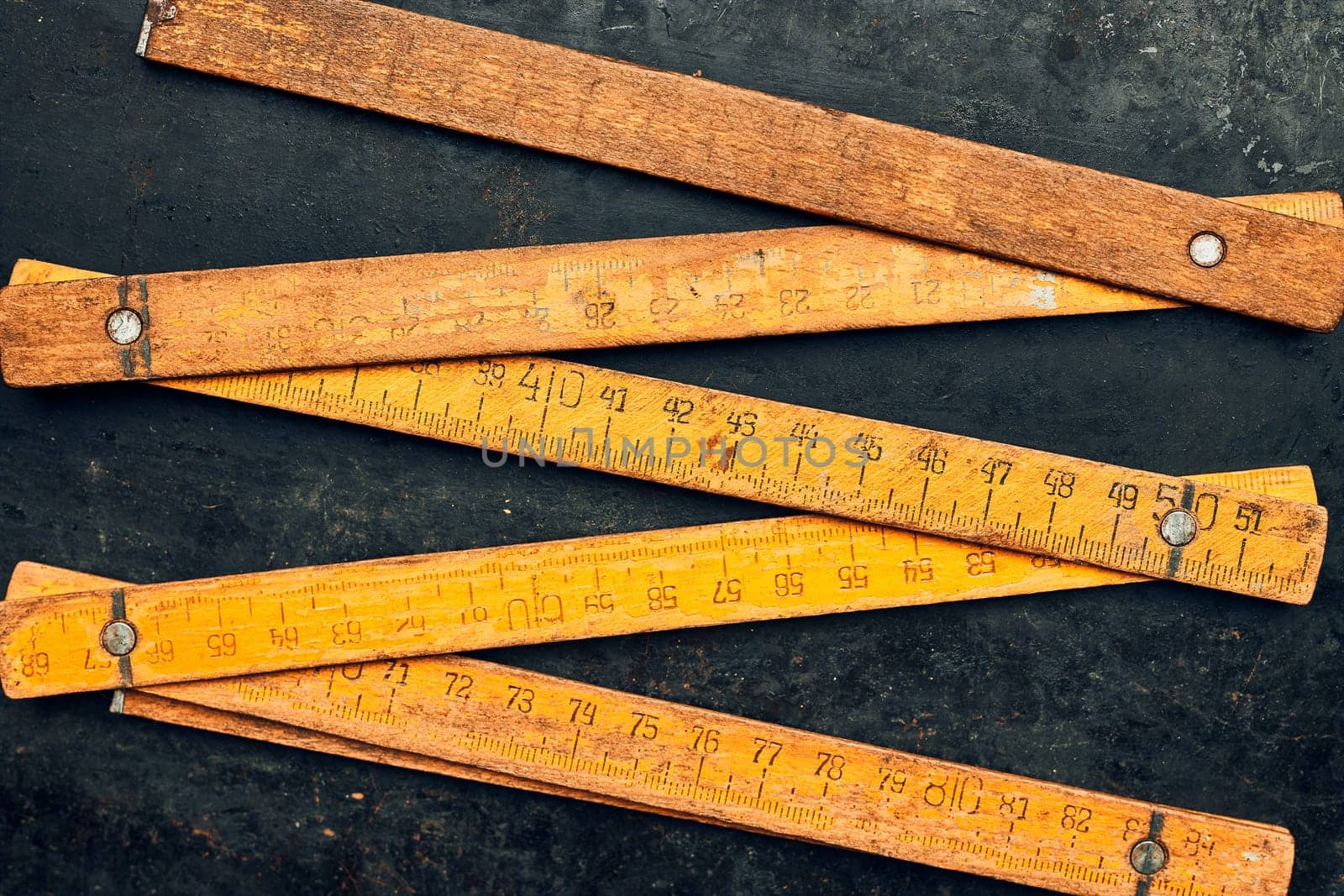 Wooden measure. Old ruler on metal surface. Measuring tool. Technical background with copy space