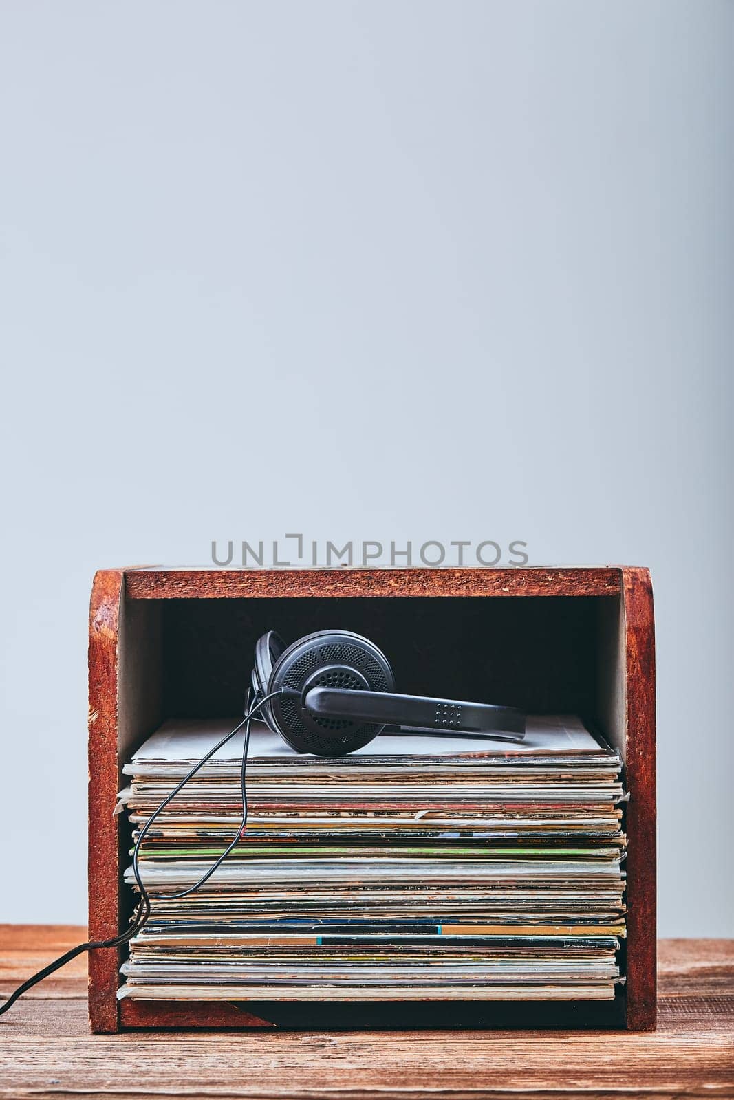 Stack of many black vinyl records and headphones put on the top of stack. Candid people, real moments, authentic situations
