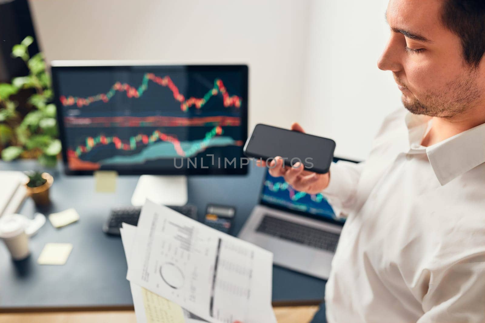 Businessman trading stocks online. Stock investor discussing numbers at graphs while phone conversation with his colleague. Business team planning and analyzing stock market graphs. Man working with stock chart data. Business man investing stock using online platform. Business success concept