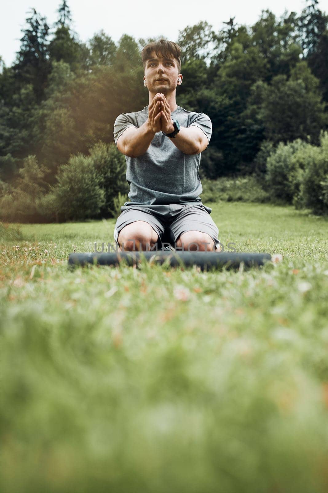 Young man doing exercises outside on grass during his calisthenics workout. Teenager training outdoors