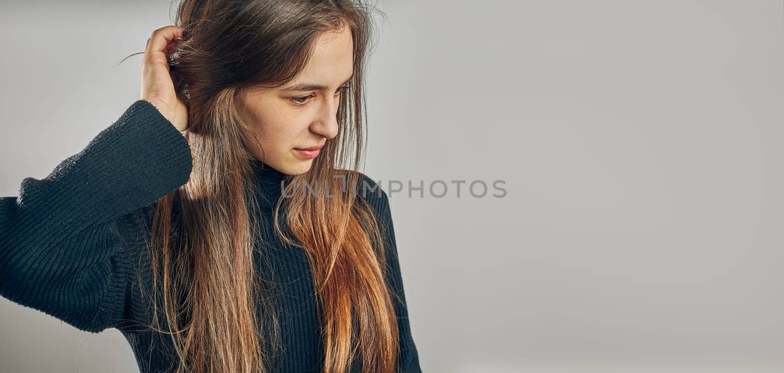 Portrait of young woman. Classic portrait in positive mood, beautiful model posing in studio over plain background looking at camera