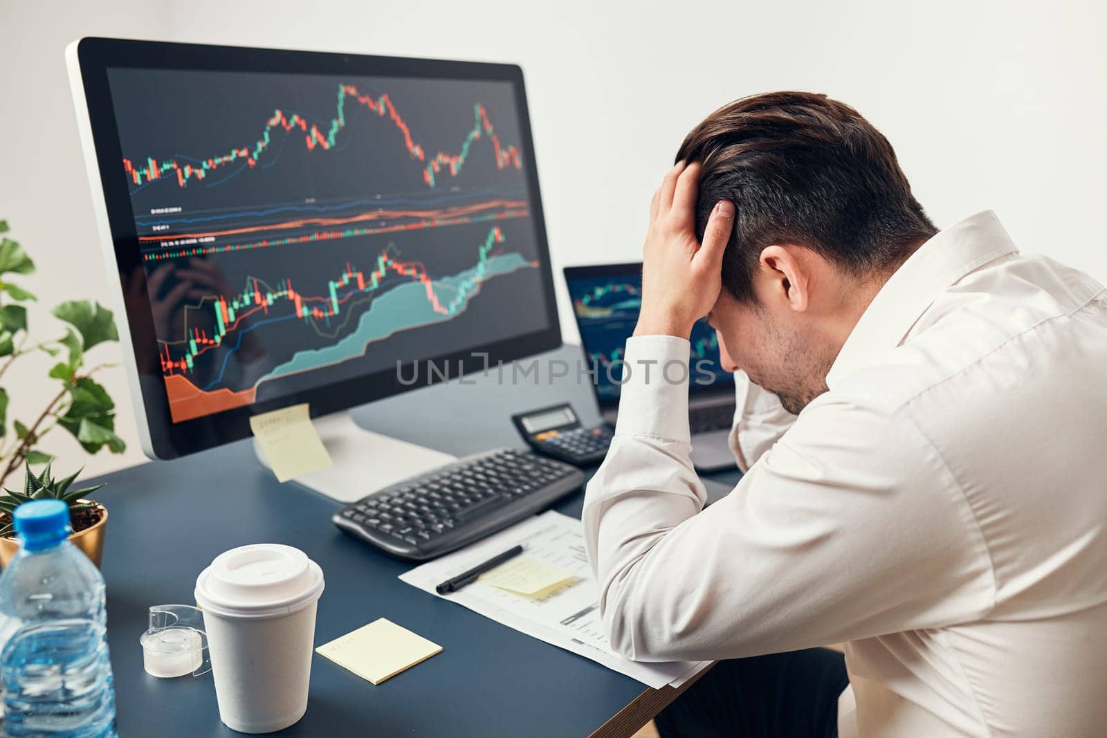Worried businessman looking at charts stressed by news from stock market. Investor lost money online. Man analyses loss and profit. Businessman investing stocks online. Man working with stock chart data. Business investing trouble concept