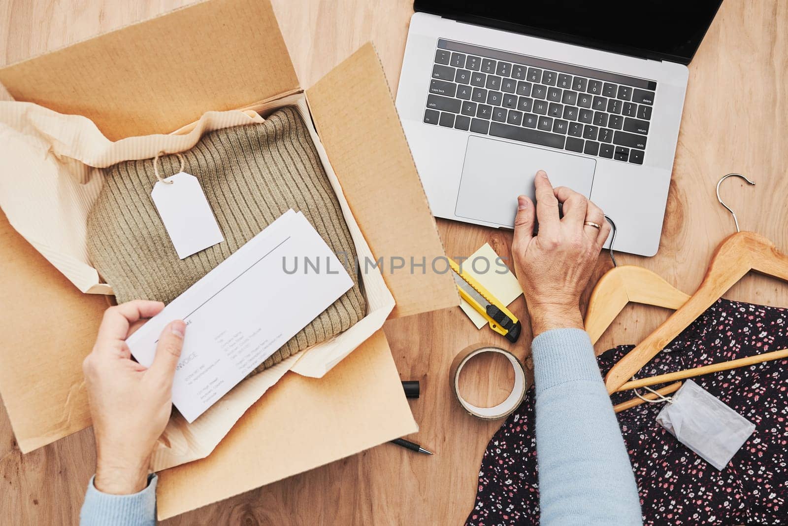 Business owner packing online order to delivery to customer. Preparing parcel box with clothes product from online shop