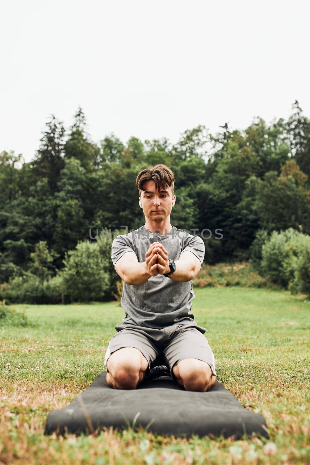 Young man doing exercises outside on grass during his calisthenics workout. Teenager training outdoors