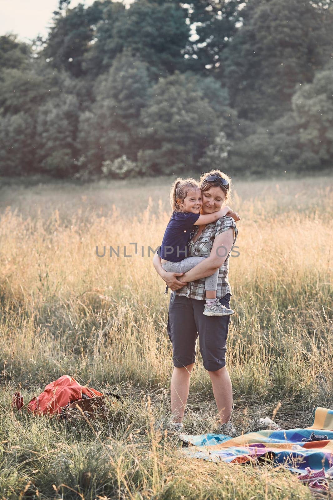 Family spending time together on a meadow, close to nature, parents and children playing together. Candid people, real moments, authentic situations
