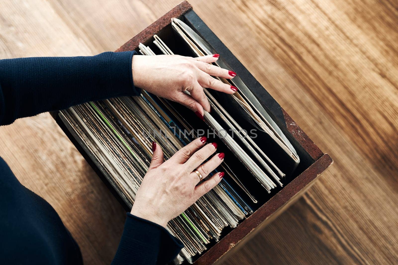 Playing vinyl records. Listening to music from vinyl record player. Retro and vintage music style. Woman holding analog LP record album. Stack of old records. Music collection. Music passion