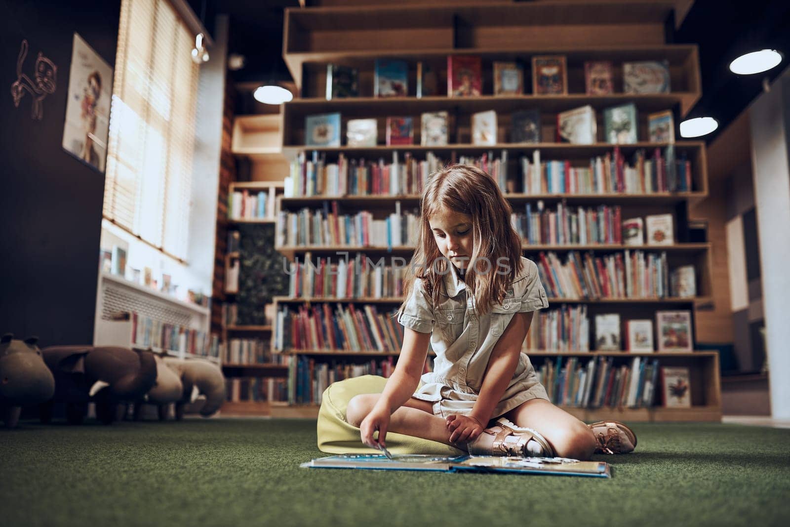 Child solving riddle in book in school library. Primary school pupil is involved in book with riddles. Smart girl learning to solve problems. Benefits of everyday practice. Child curiosity