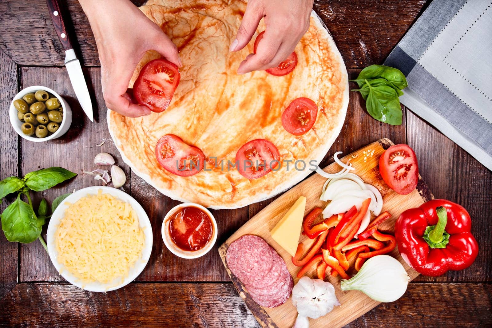 Ingredients, cheese, vegetables prepared for homemade pizza, on wooden board on the table. View from above