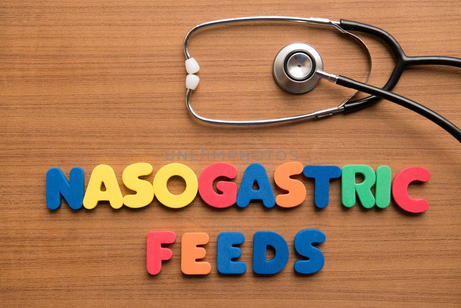 Nasogastric feeds (NG feeds) colorful word with stethoscope on the wooden background