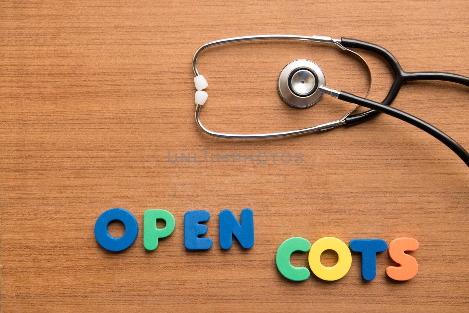 Open cots colorful word with stethoscope on the wooden background