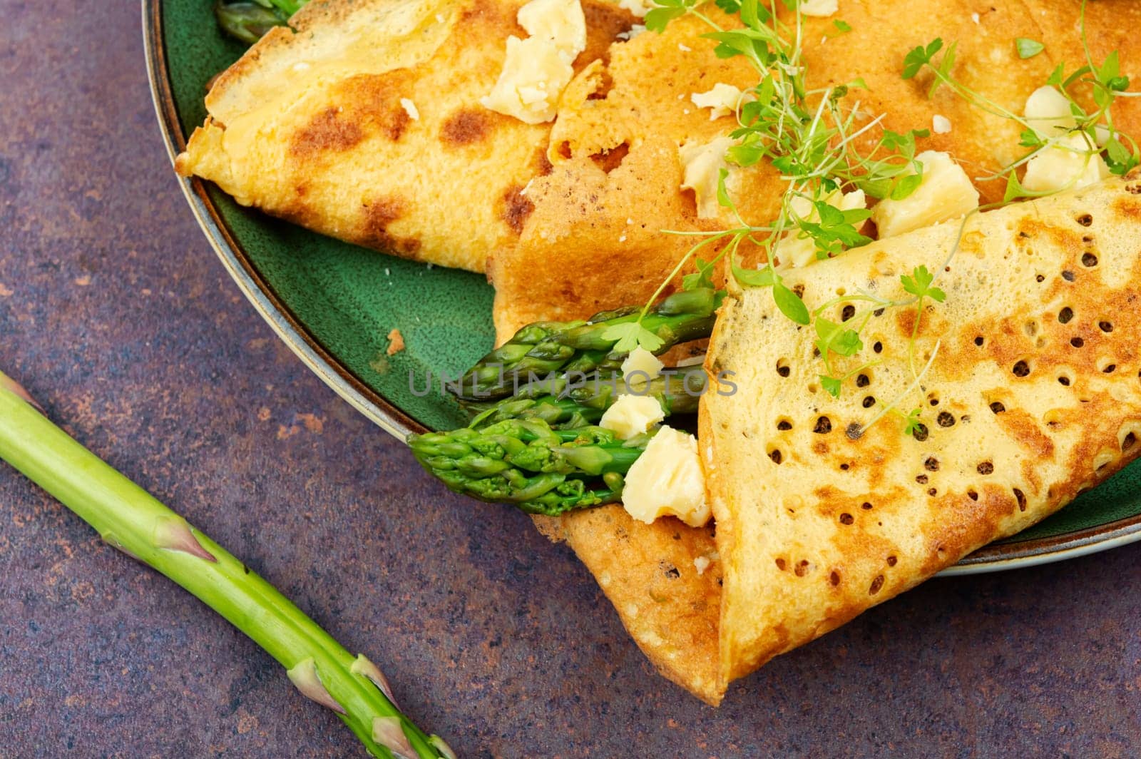 Egg omelet stuffed with green asparagus, cheese and herbs.