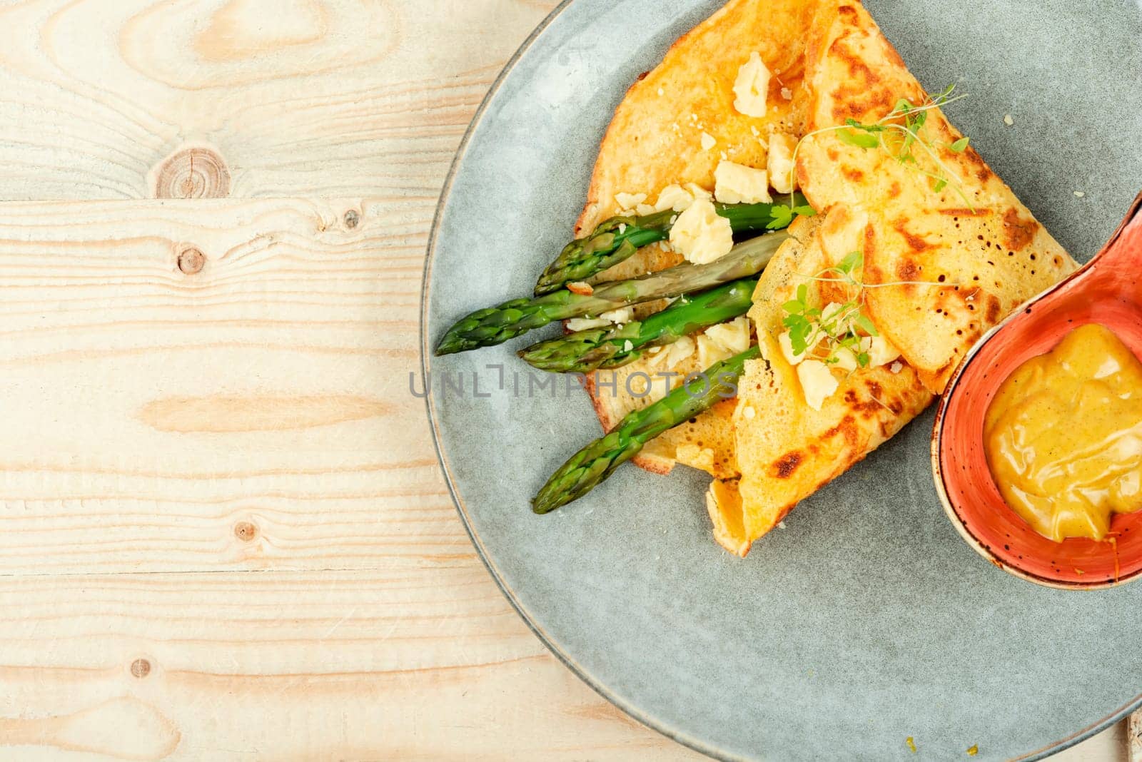 Egg omelet stuffed with green asparagus, cheese and herbs.