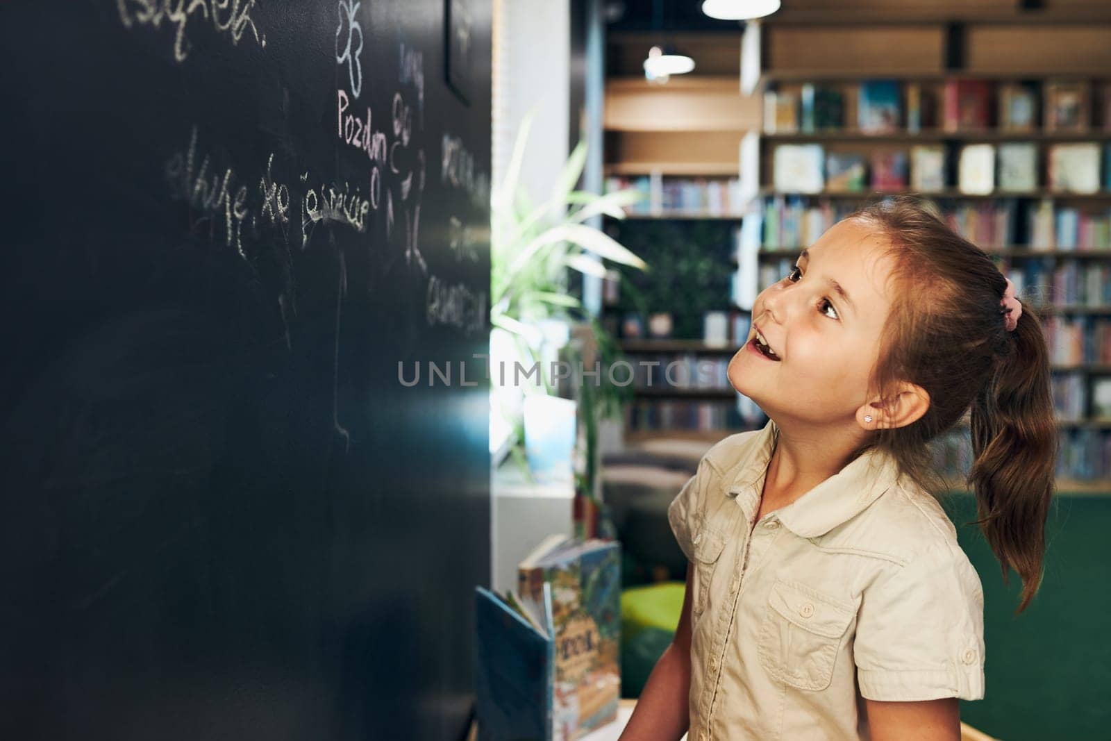 Little girl writing on blackboard. Smart student put solve on chalkboard. Back to school. Child having class. Schoolgirl learning at primary school. Elementary education