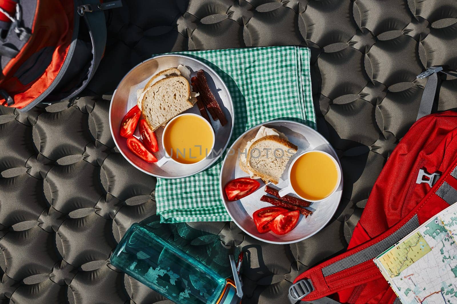 Breakfast at camping outdoors. Plates with sandwiches on outdoor mat. Concept of camp life