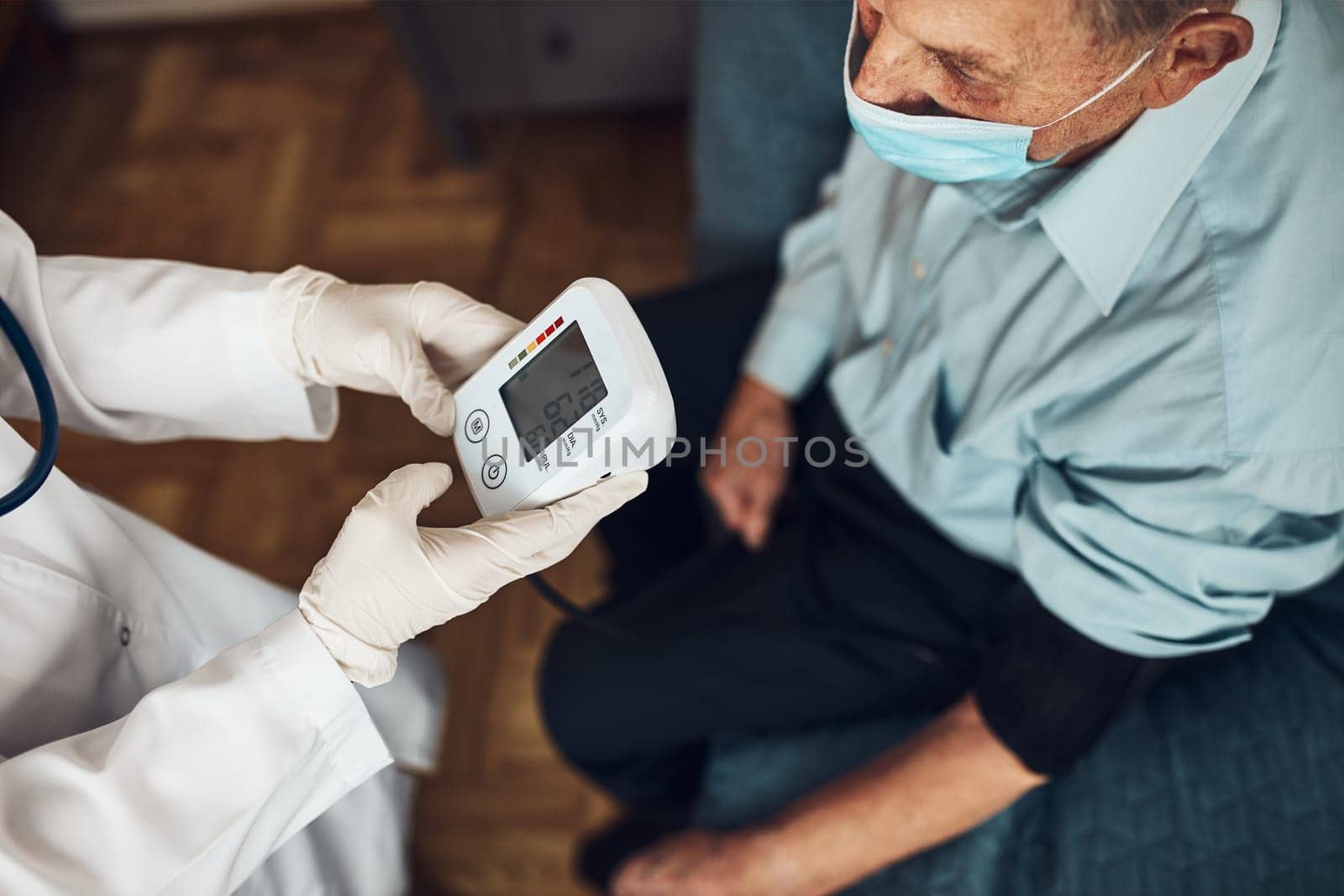 Doctor carying out blood pressure test and heart rate of senior man. Checking health condition elder patient suffering from arterial hypertension