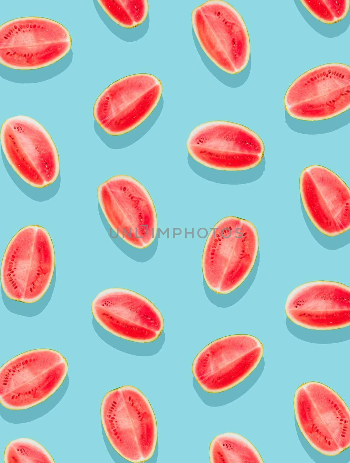 Watermelon pattern. Slices of watermelon on a plain surface painted in bright blue