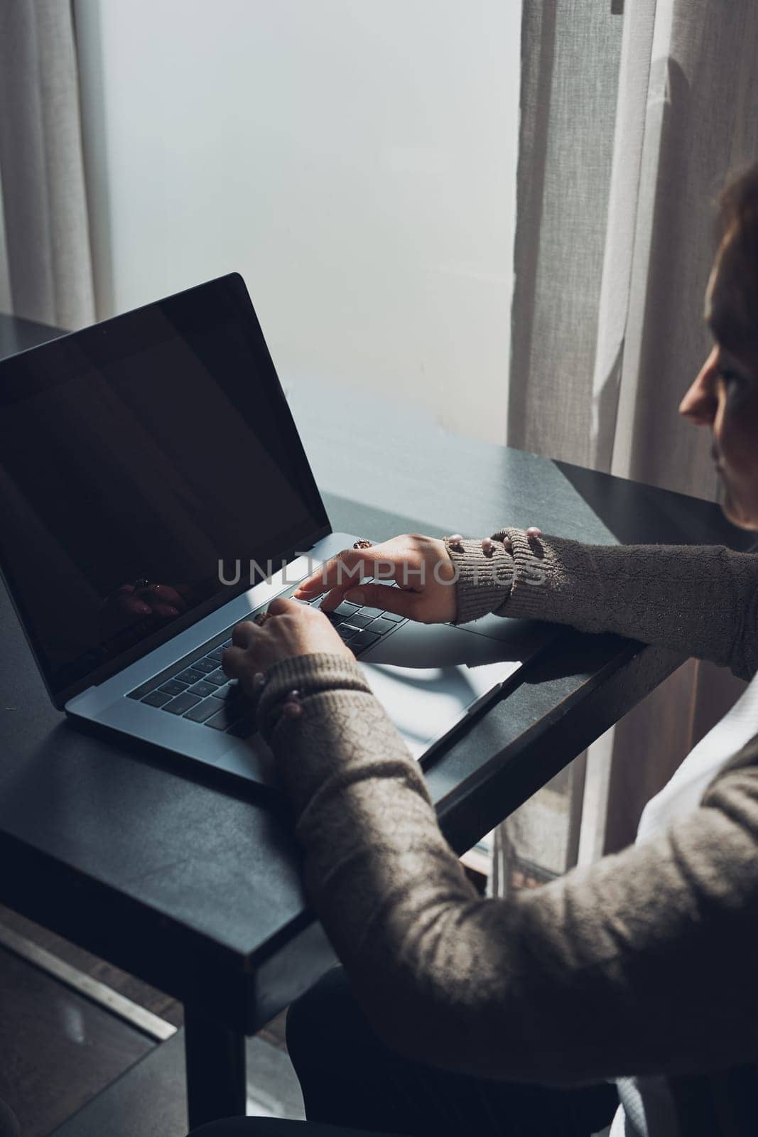 Focused businesswoman working remotely on her laptop computer contemplate managing her work sitting at the table in a cafe
