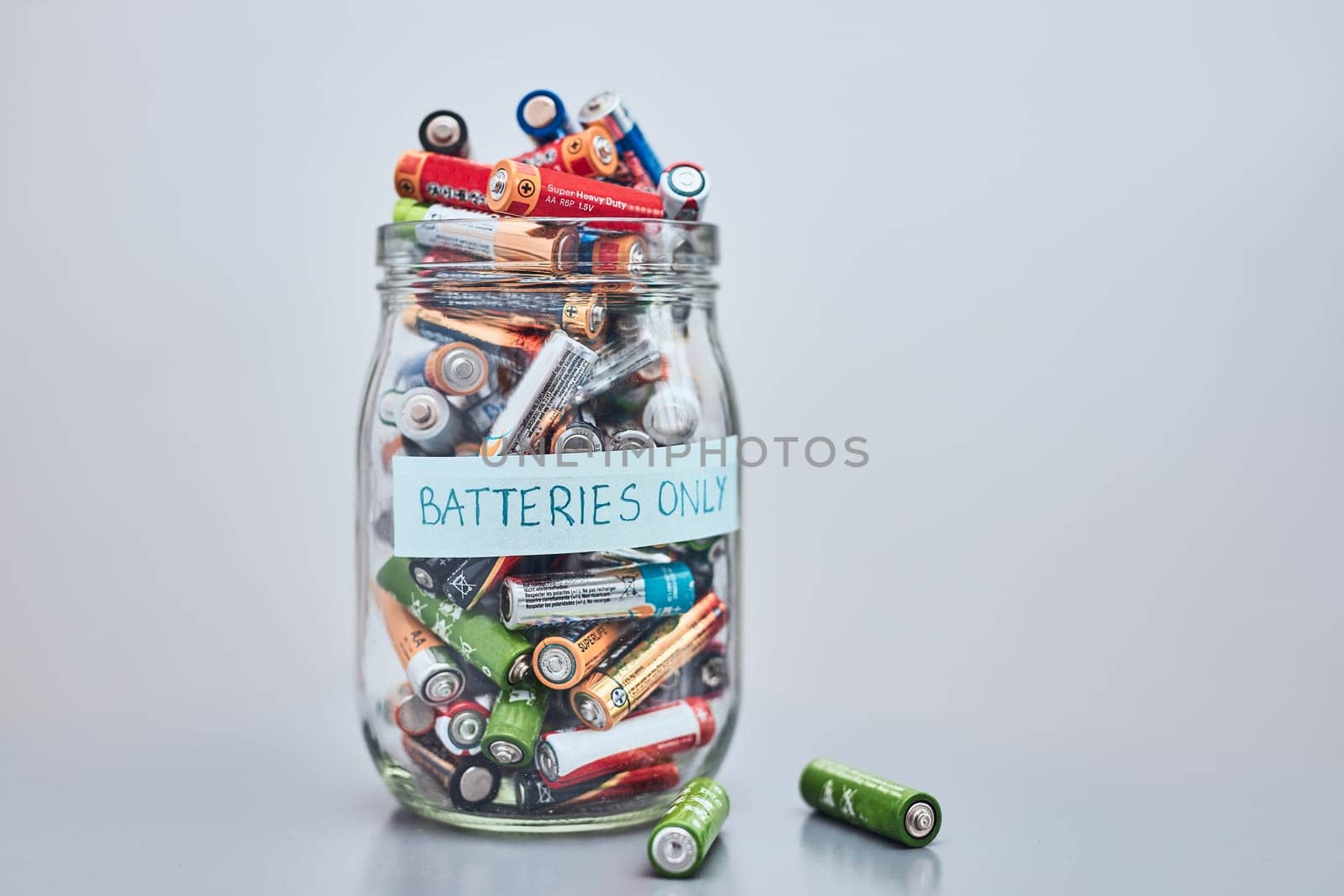 Jar filled with discharged used batteries. Waste disposal and recycling. Separating the waste. Batteries only container