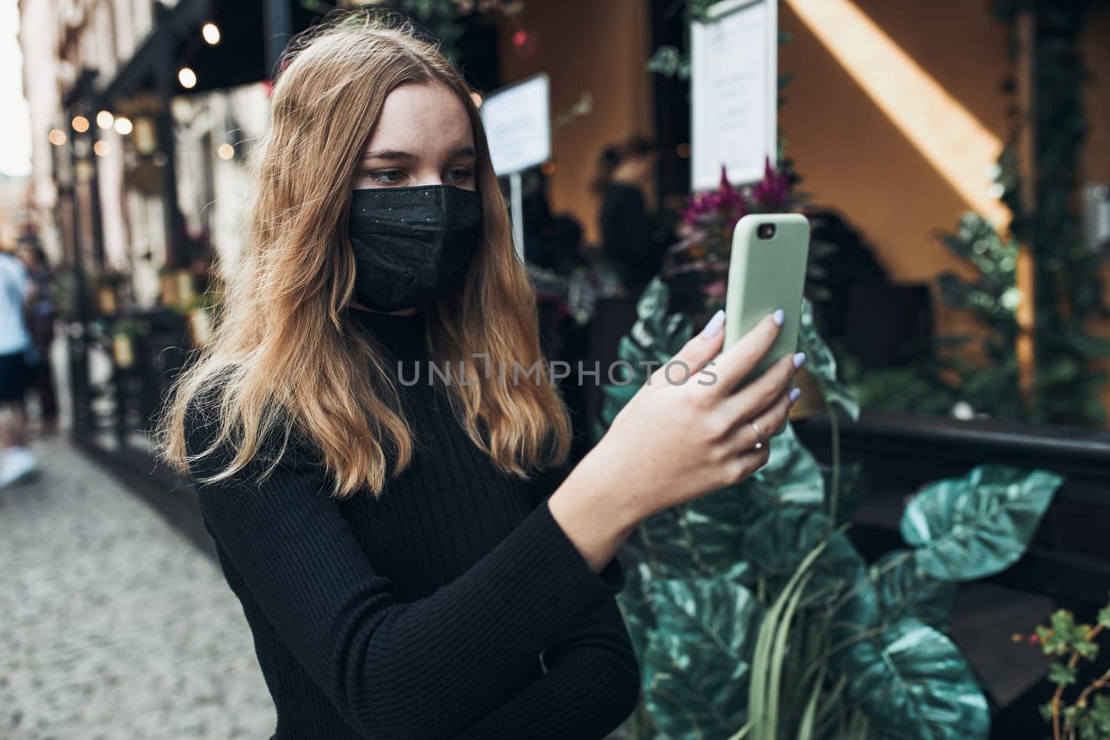 Young woman having video call talking while walking downtown wearing the face mask to avoid virus infection and to prevent the spread of disease in time of coronavirus