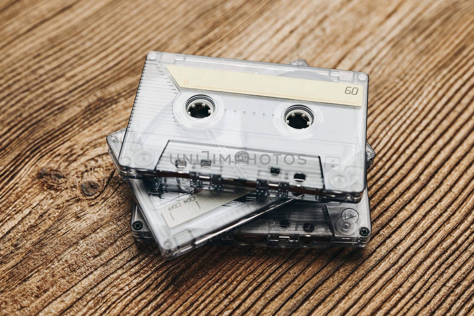 Tape cassettes. Magnetic cassette tapes on wooden table. Retro music style. 80s music party. Vintage style. Analog equipment. Stereo sound. Back to the past