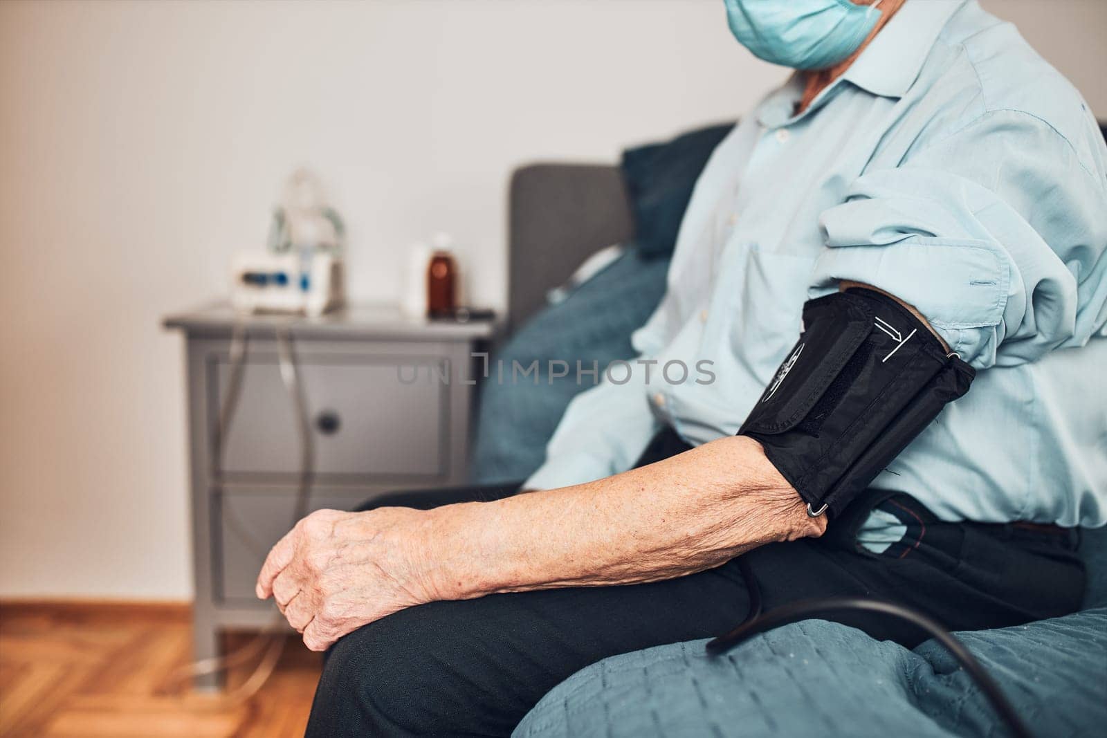 Senior man measuring blood pressure and heart rate himself. Checking health condition elder patient suffering from arterial hypertension