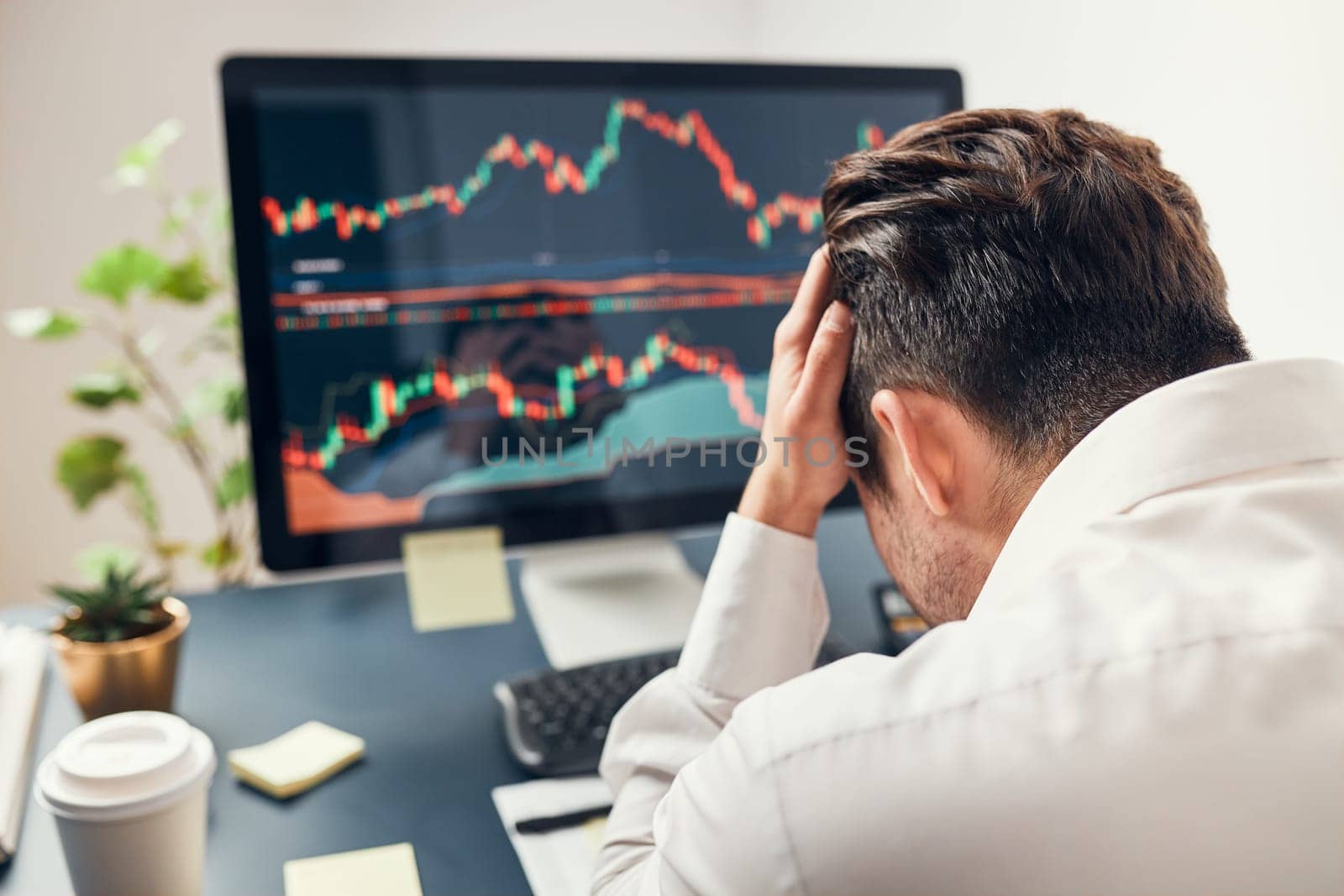 Worried businessman looking at charts stressed by news from stock market. Investor lost money online. Man analyses loss and profit. Businessman investing stocks online. Man working with stock chart data. Business investing trouble concept
