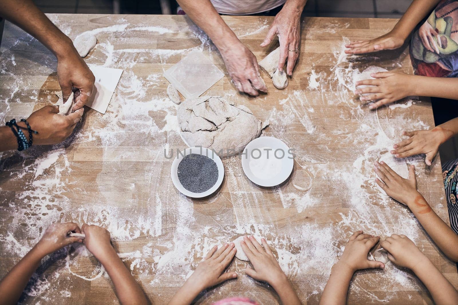 Hands kneading dough. People making dough for bread during bread making workshop. Flour and raw dough on wooden table