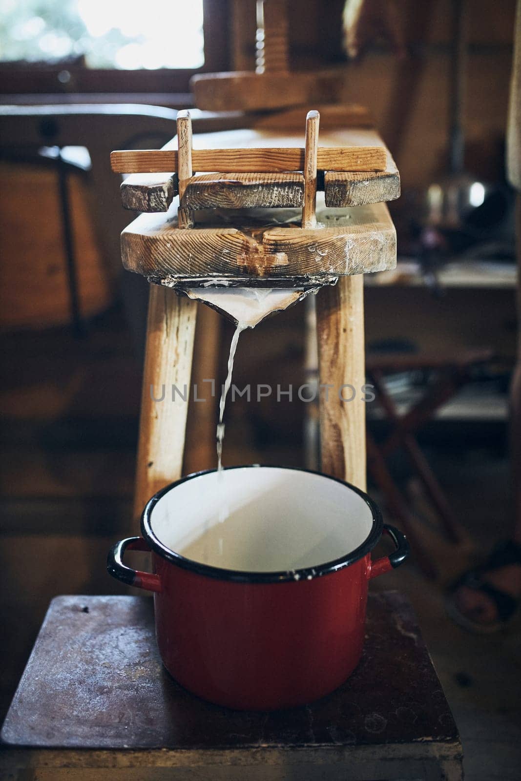 Cheese making. Making cottage cheese using cheese press and traditional old technique. Old rustic kitchen