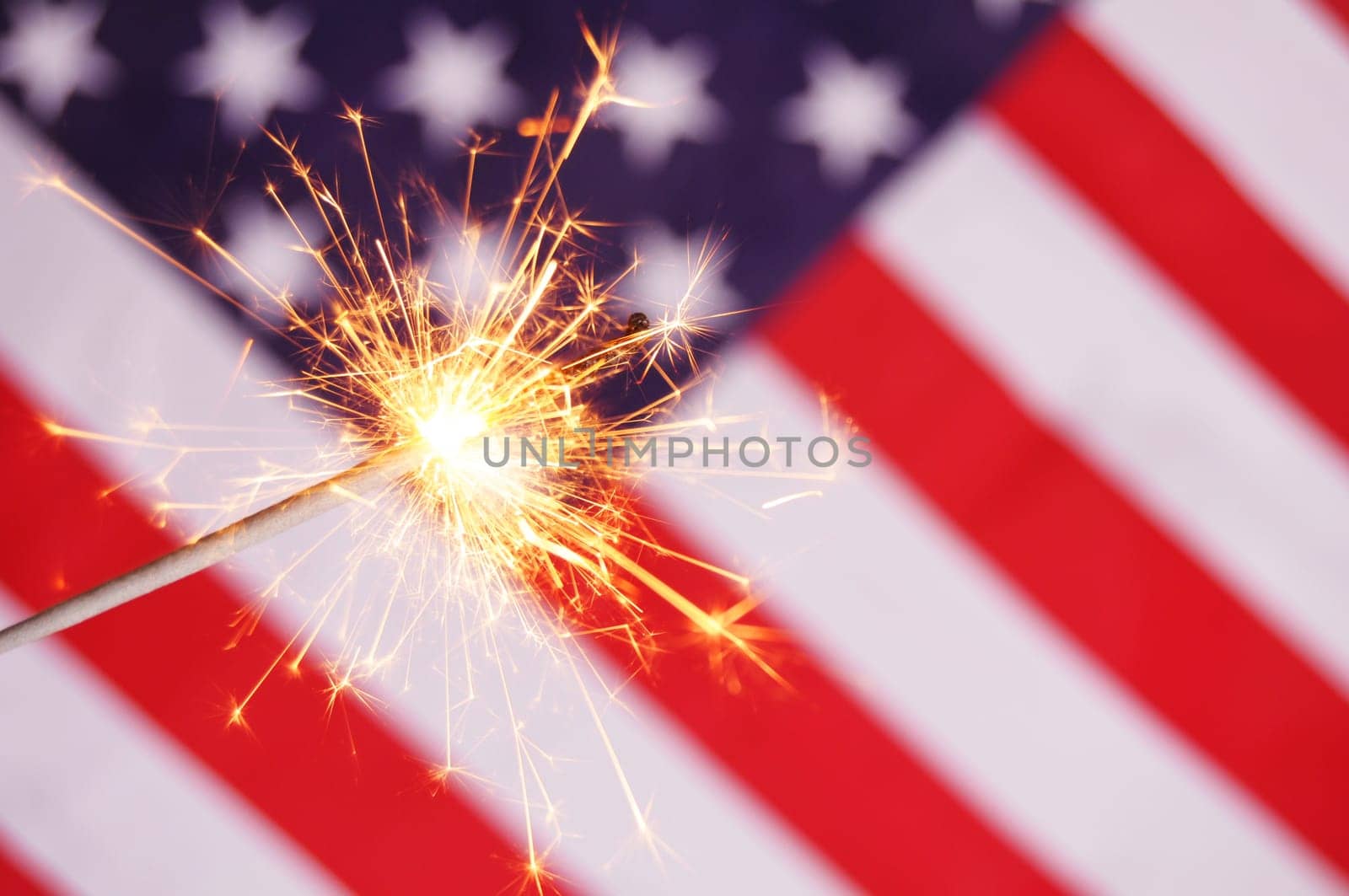 sparkler and usa flag showing 4th of july
