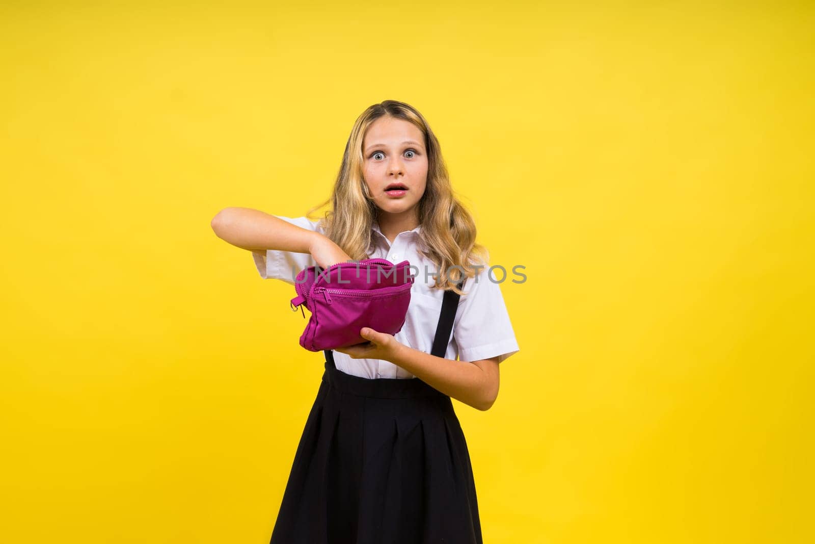 Happy schoolgirl with colored pencils and pencil case in hand