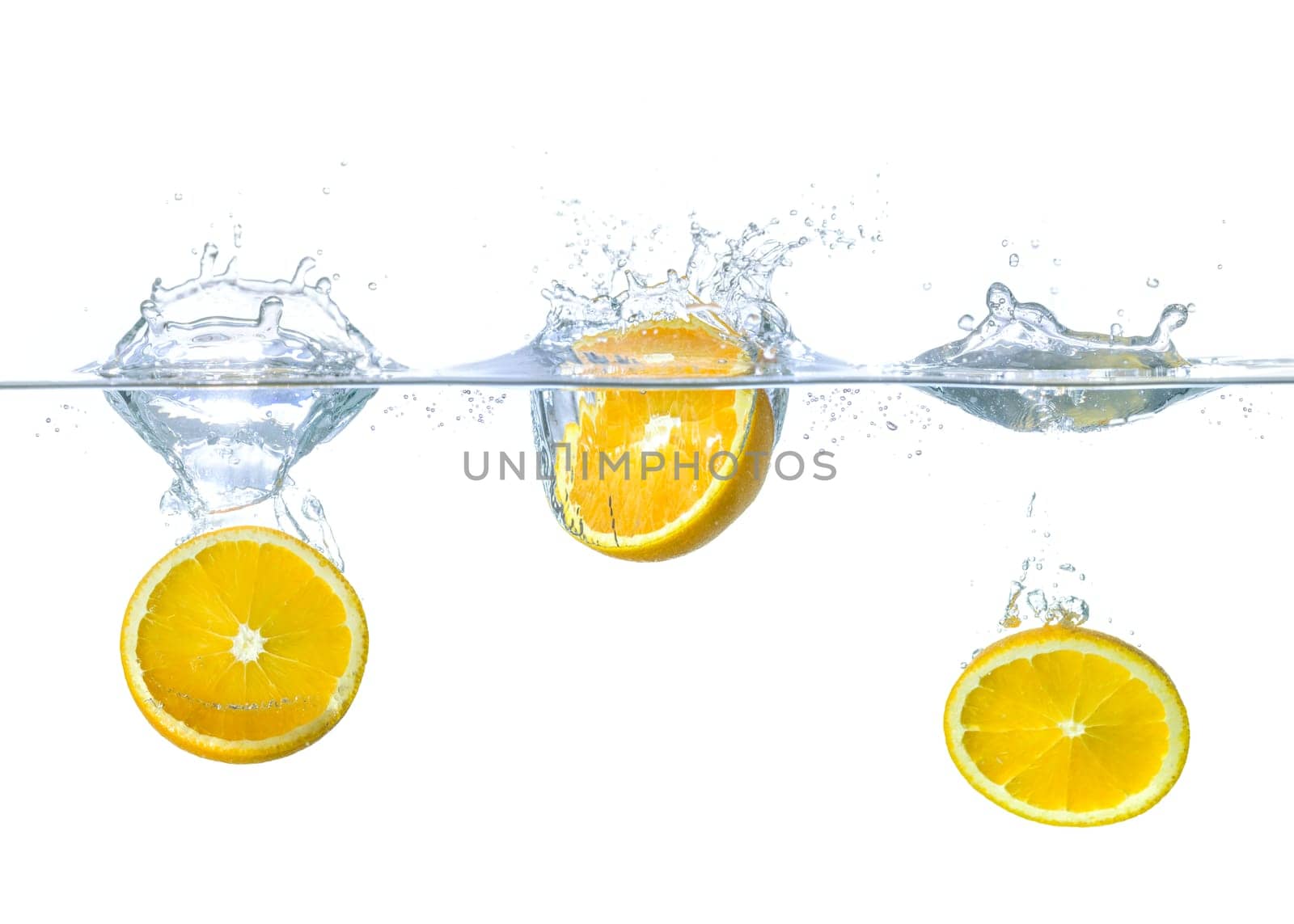 Oranges fall into the water with splashes