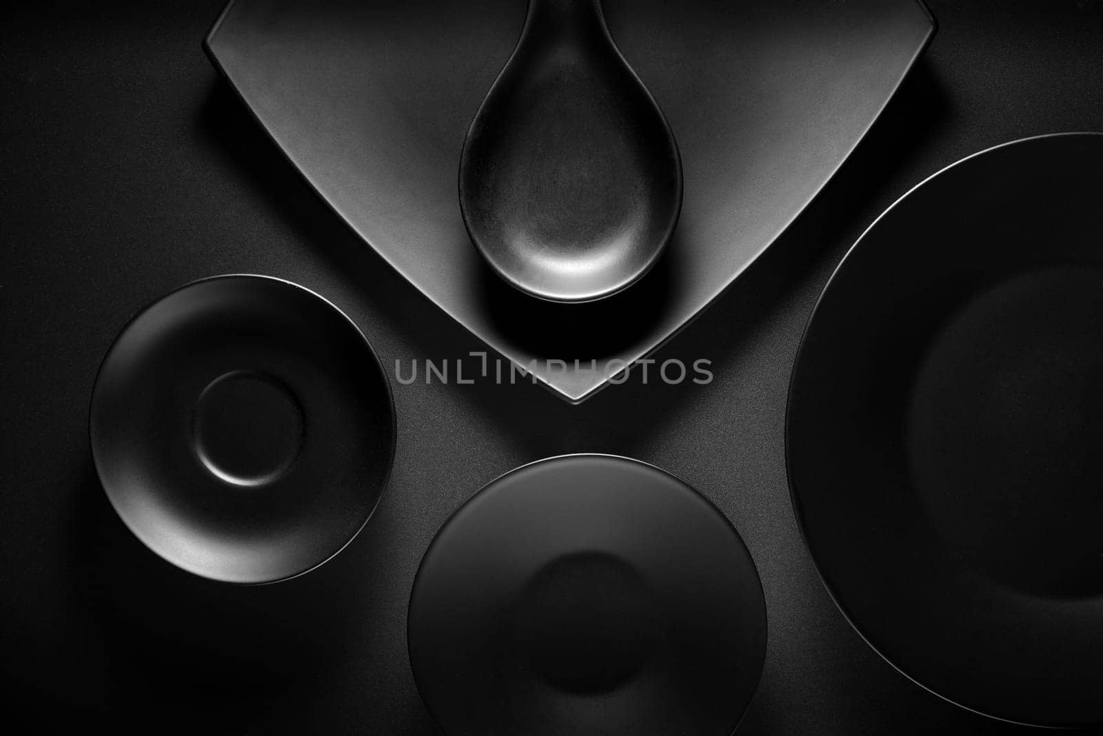 Top view of black empty plates on dark grey background