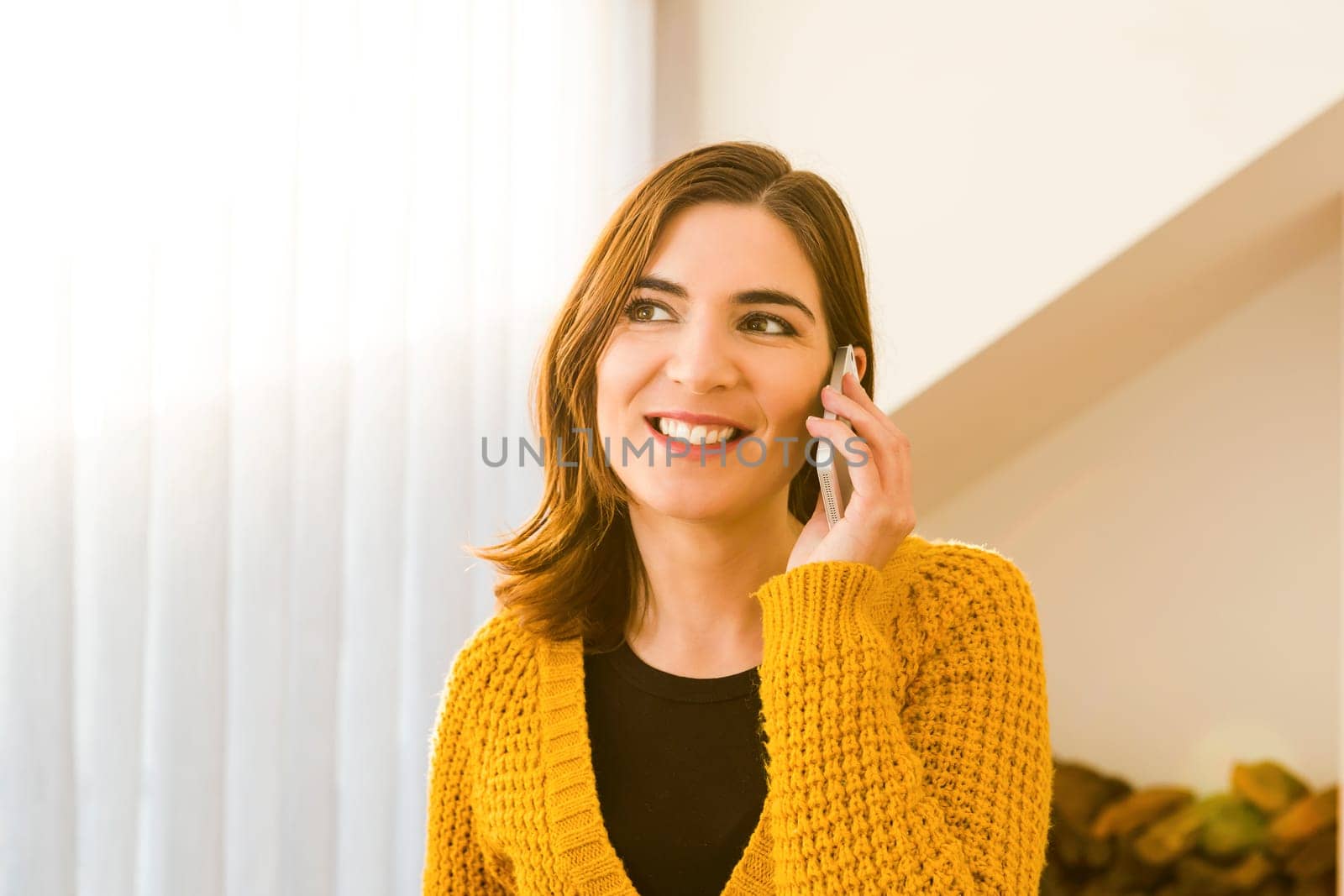 Gorgeous young woman at home texting and laughing