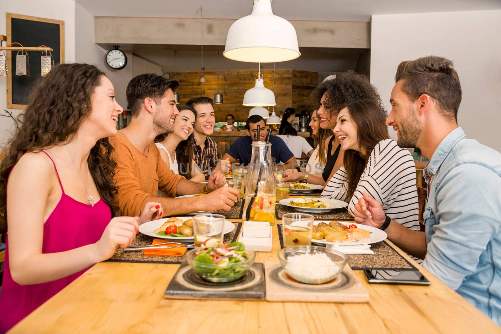 Multi-Ethnic Group of happy friends lunching and having fun at the restaurant