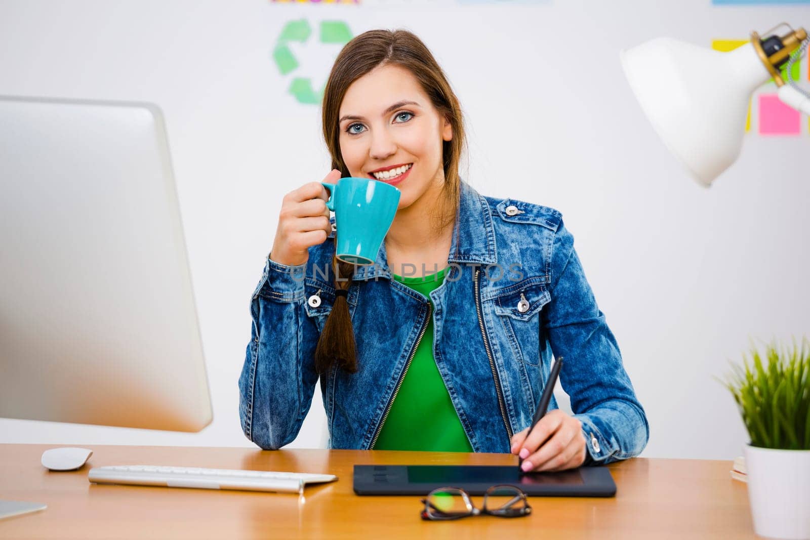 Woman working at desk In a creative office, making a call