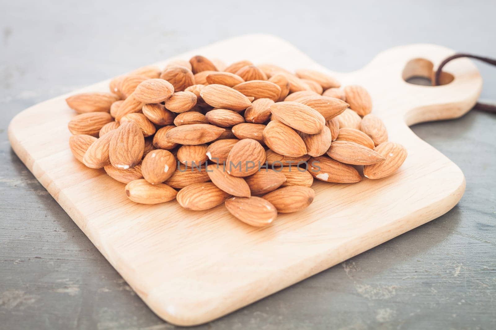 Almond nuts on wooden plate, stock photo