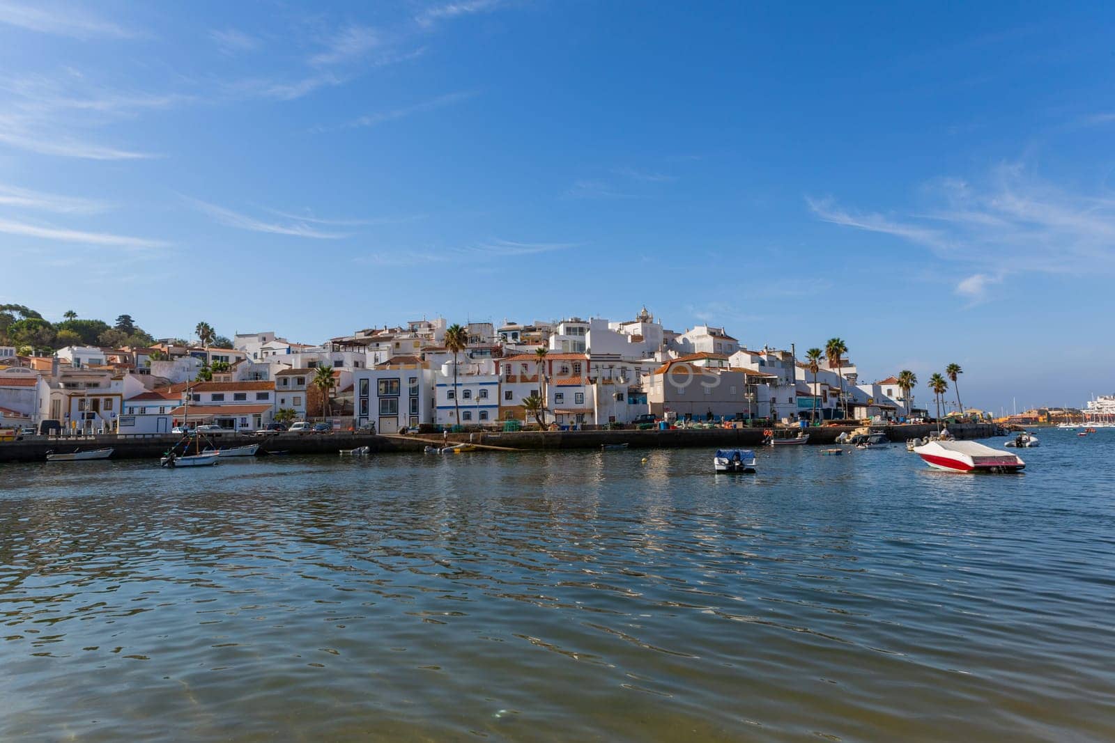 Ferragudo, Portugal - August 25, 2022 - View of the white town with boats moored in the foreground, Ferragudo, Algarve, Portugal, Europe