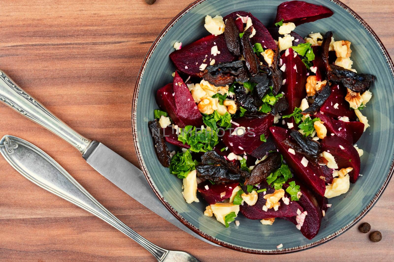 Diet salad of boiled beets, nuts and goat cheese on the plate. Flat lay.