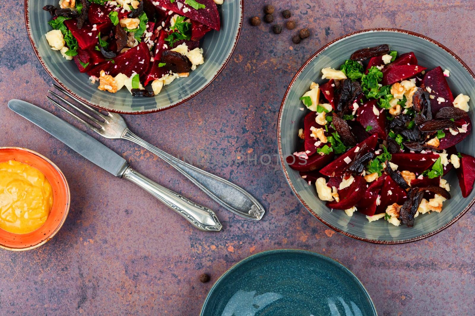 Diet salad of boiled beets, nuts and goat cheese on the plate. Flat lay.