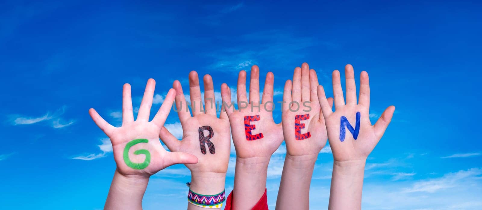 Children Hands Building Colorful English Word Green. Blue Sky As Background.